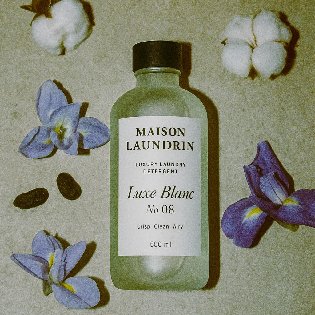 Luxe Blanc laundry detergent flat lay with cotton flower and iris scent notes
